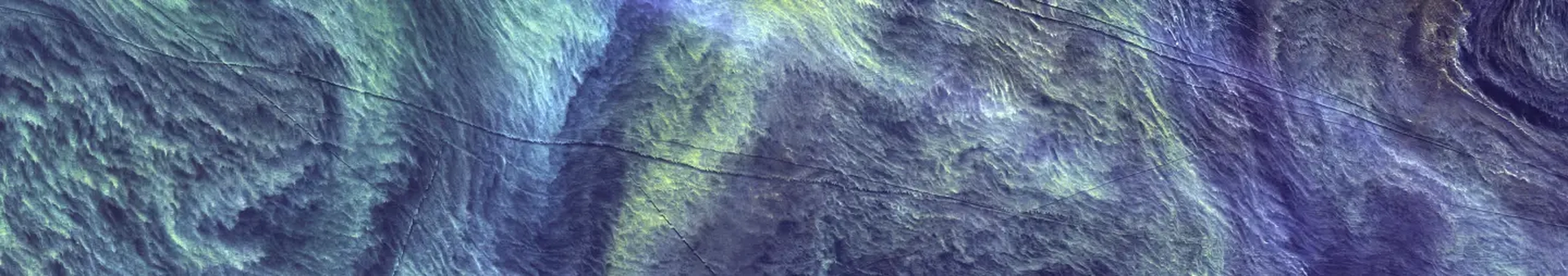 Satellite view of the ocean with swirling patterns and thin dark lines.